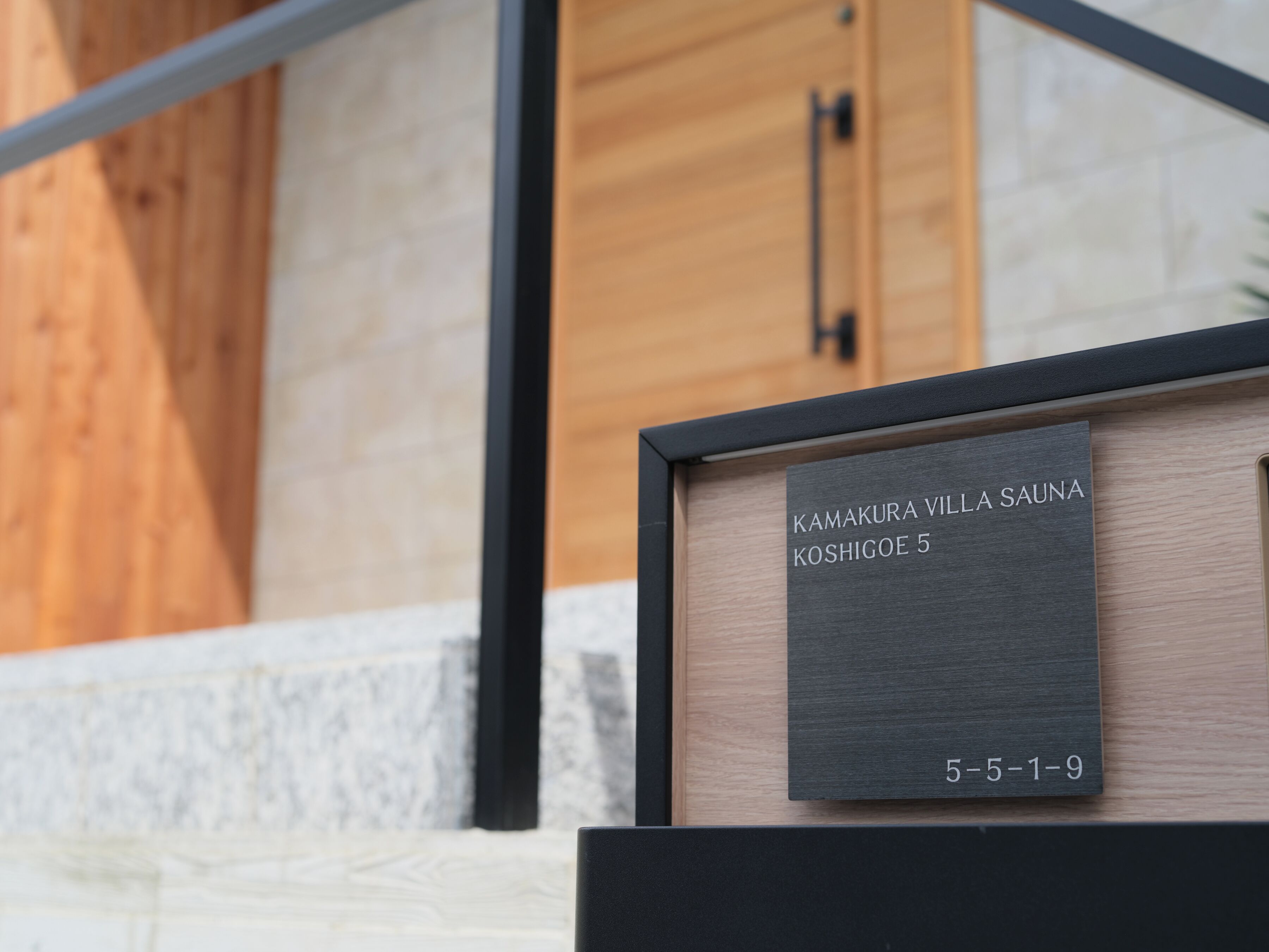 A framed sign with the text 'KAMAKURA VILLA SAUNA KOSHIGOE 5' and a date '5-5-1-9'.
