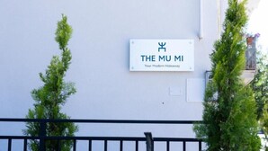 A sign on a white wall with the text 'THE MU MI Your Modern Hideaway.'