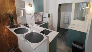 Una cucina compatta con isola centrale, forno a microonde e dispenser d'acqua.
