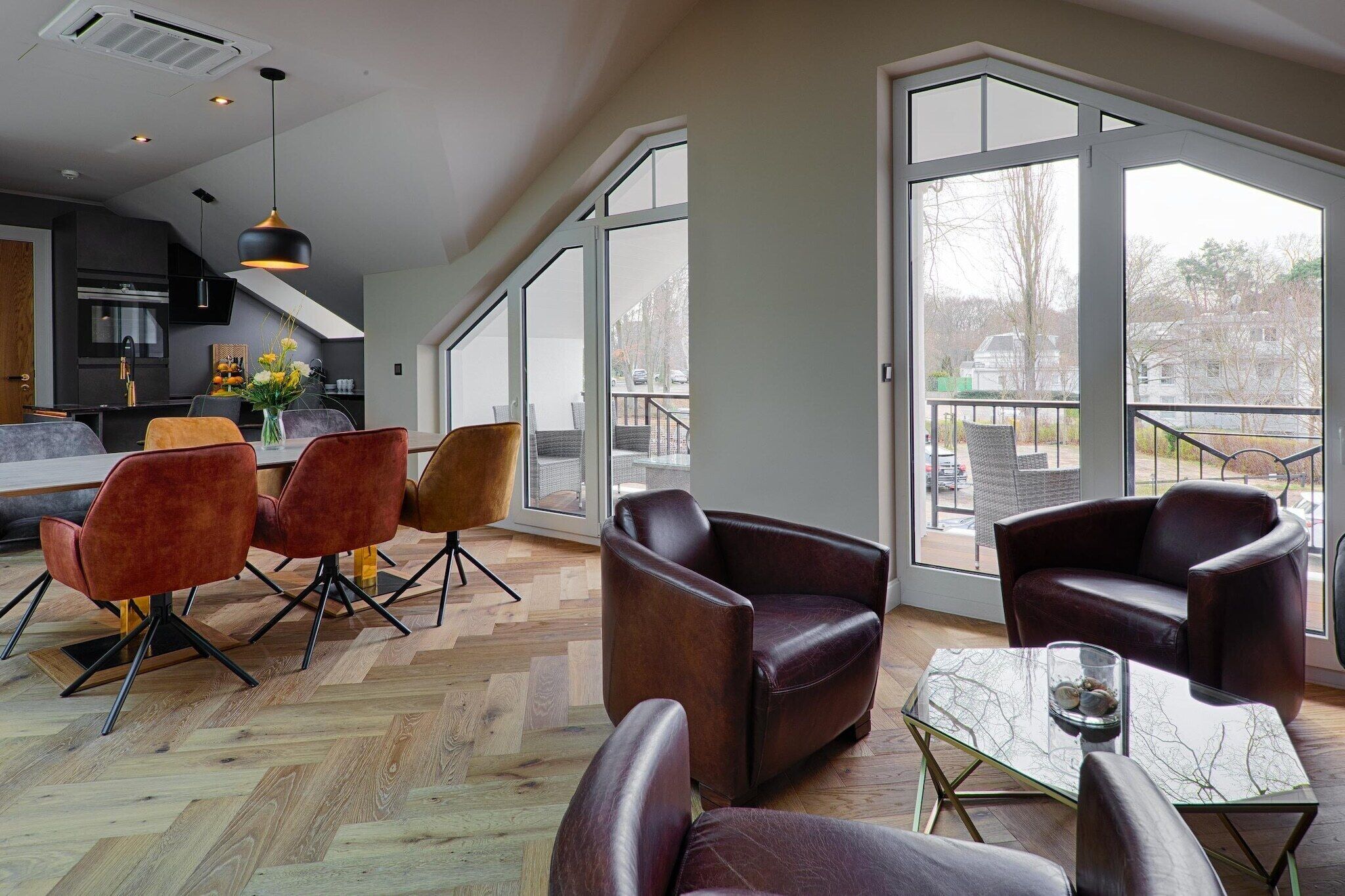 Un espacio habitable espacioso con una cocina moderna, ventanas amplias y asientos cómodos.