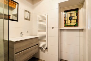 Ein Badezimmer mit einem weißen Waschbecken, einem Waschtisch und einem Handtuchhalter.