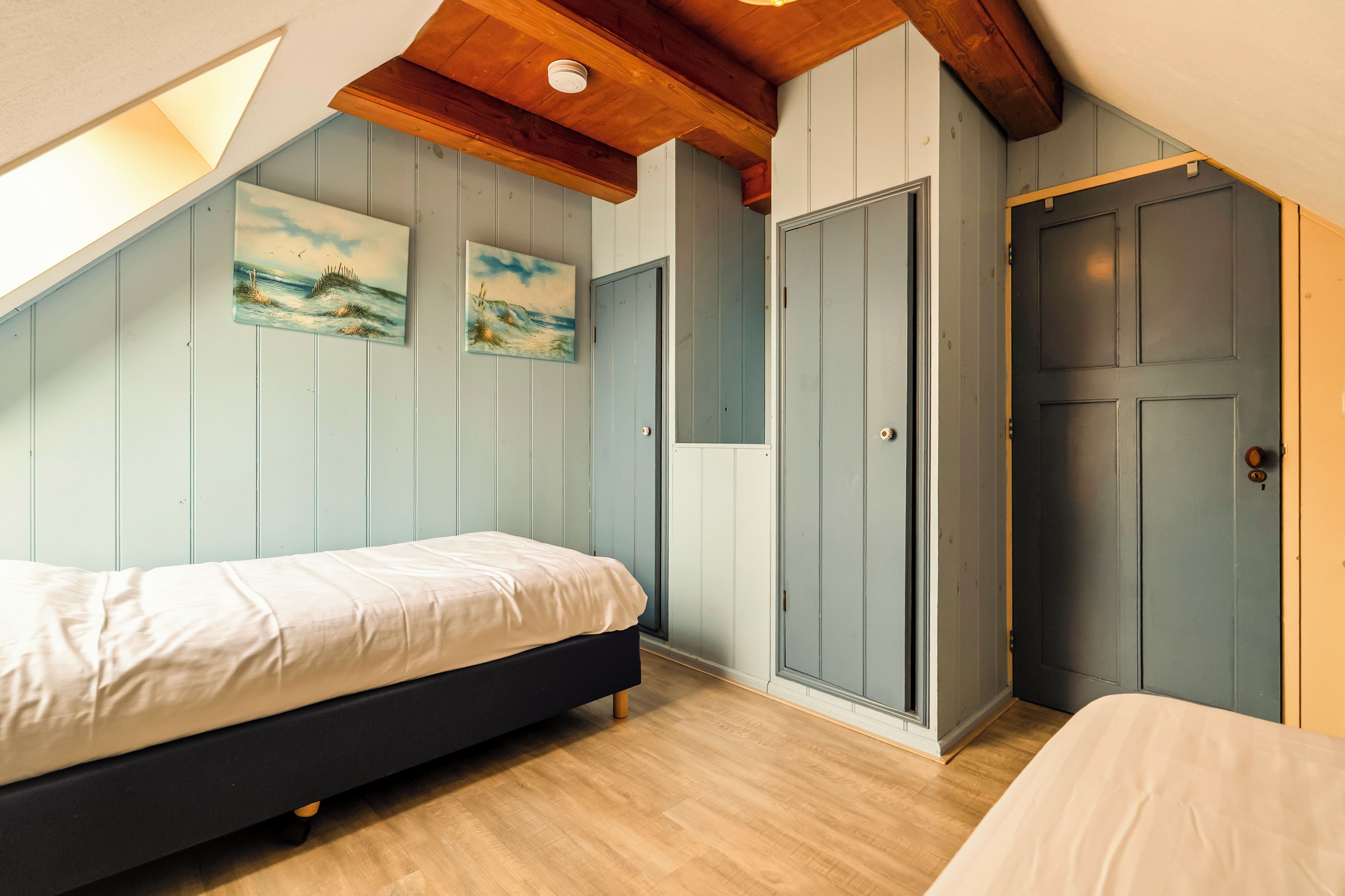 Een slaapkamer met een bed, een kledingkast en een deur.