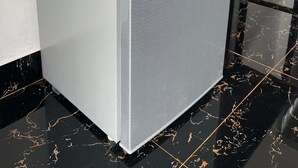 A refrigerator with a metallic finish, a control panel, and a sticker on the top.