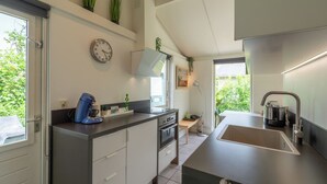 Cozinha moderna com forno embutido, cafeteira e pia.