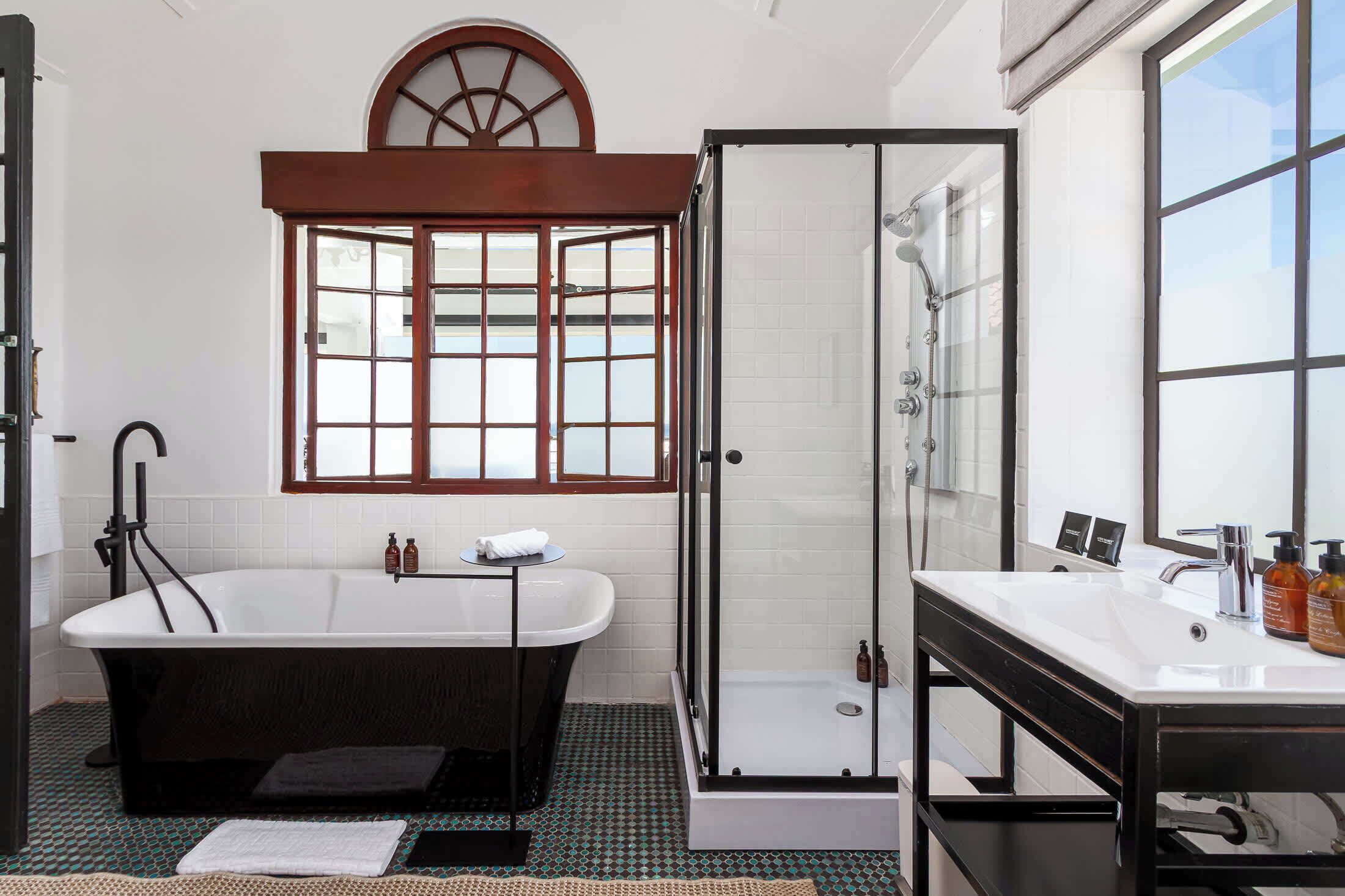 Une salle de bain moderne avec une baignoire sur pieds, une douche à parois de verre et un meuble-lavabo avec un miroir.