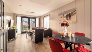 Et moderne interiør med spiseplads, sofaer og et maleri på væggen.
