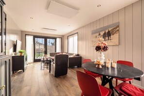 A modern interior with a dining area, sofas, and a painting on the wall. - Zand Vacation Home – Luxury, Peace, and Space on the Coast (Julianadorp)
