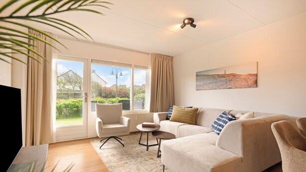 A modern living room with a sofa, armchairs, a coffee table, and a painting on the wall. - A beautiful, modernly furnished vacation rental for 4 people, located right across from the beach entrance in Callantsoog! (Callantsoog)