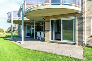 A residential building with a covered patio, a sliding glass door, and a brick exterior. - Beautiful vacation rental for 4 people across from the wide dunes of Julianadorp aan Zee! (Julianadorp aan Zee)