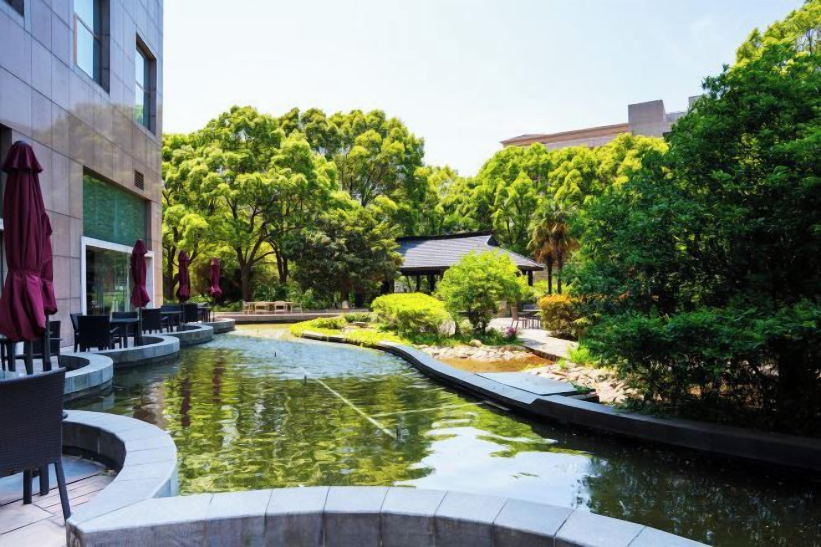 A courtyard with a water feature, seating, and greenery.