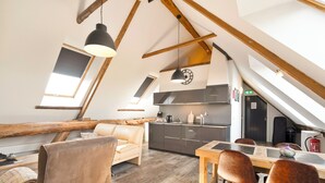 A loft-style living space with a kitchen, dining area, and seating area. - Beautiful apartment in an authentic Stolp farmhouse (Schagen)