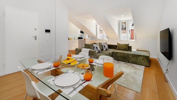 A modern apartment with a dining area, kitchen, living space, and a TV. - Comfortable Family Apartment in Central Lisbon (Lisbon)