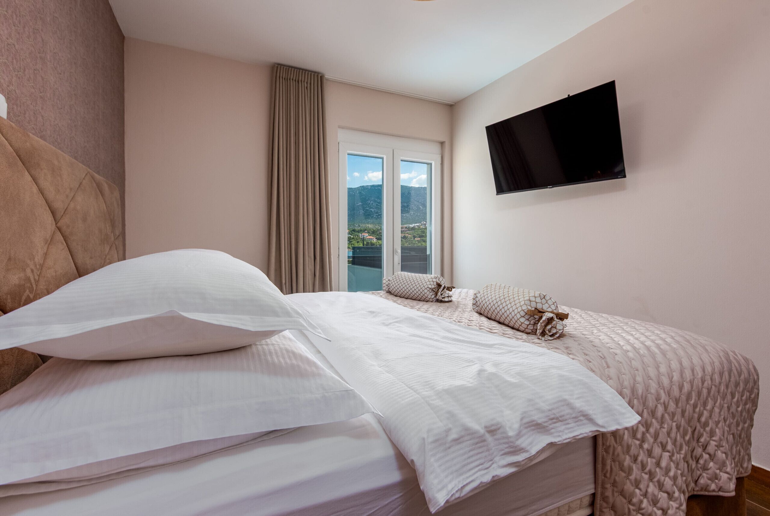 Un dormitorio con cama, televisión y ventana con vistas.