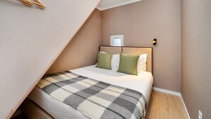 Quarto com cama, cabeceira, janela e porta.