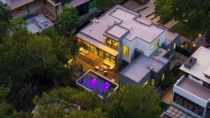 Une maison moderne dotée d’une piscine, de plusieurs niveaux et d’un jardin bien entretenu.