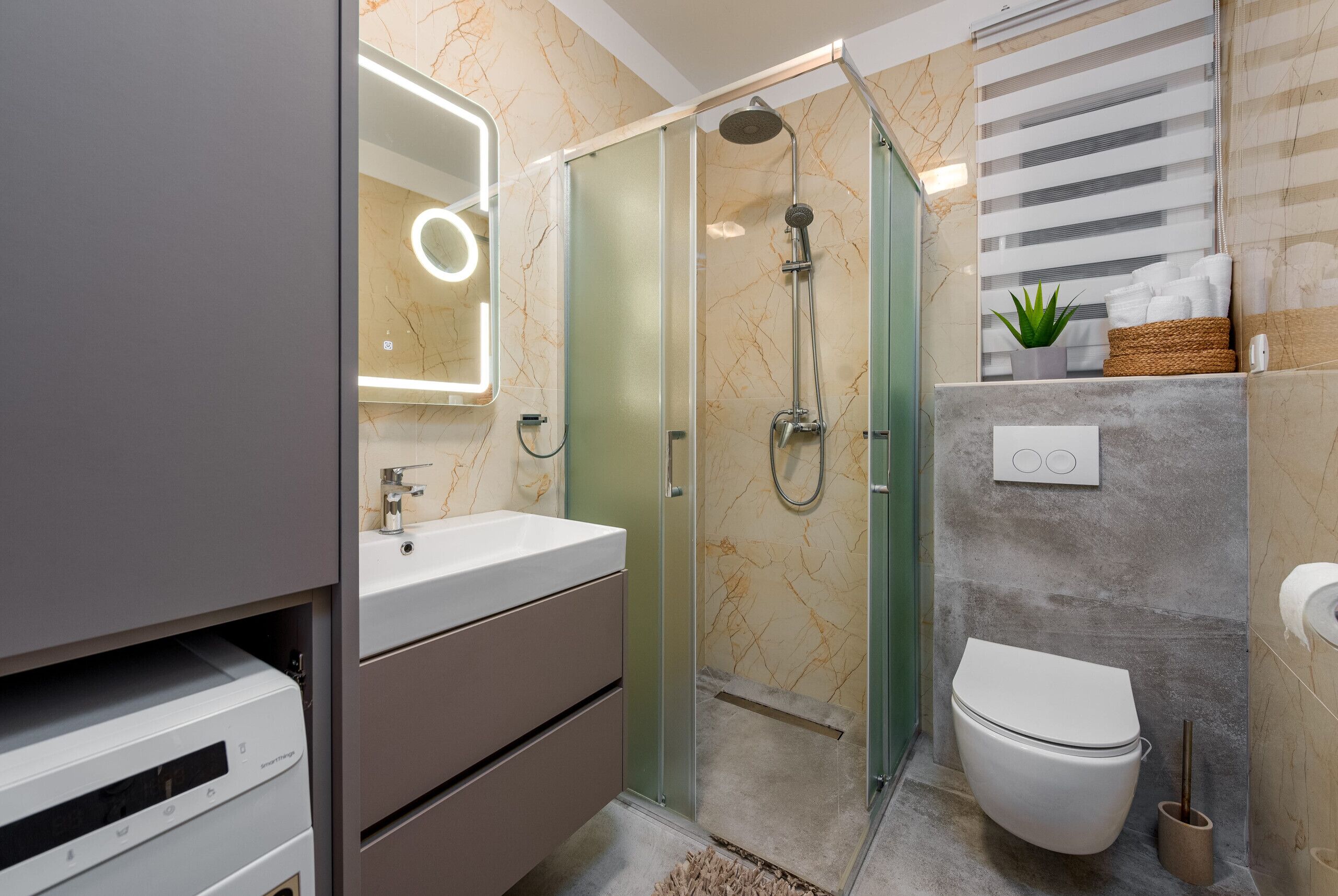 A modern bathroom with a glass-enclosed shower, a white toilet, and a vanity with a mirror.