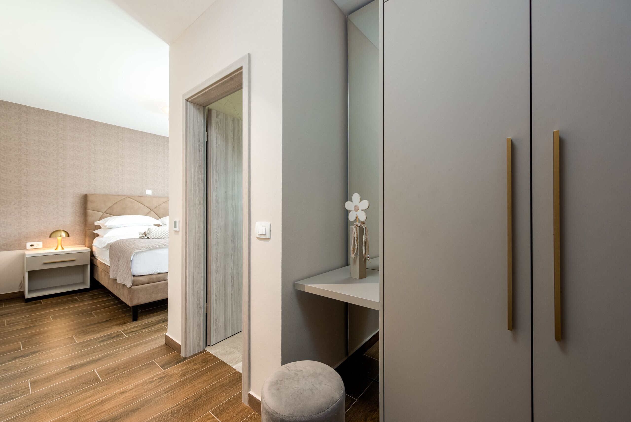 Un dormitorio con cama, mesita de noche y espejo.