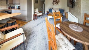 A modern kitchen with a dining area, wooden furniture, and a large painting on the wall. - Louisa Bay - UK51814 (Broadstairs)