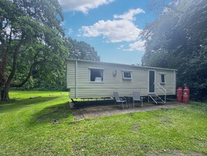 A mobile home with a small porch, two windows, and a door. - 2 bedroom accommodation in Hevingham (Hevingham)