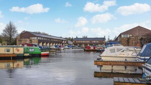 A marina with boats docked, a building with a stone facade, and a clear sky. - 1 bedroom accommodation in Carnforth (Carnforth)