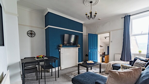 A living room with a TV, fireplace, dining table, and seating area. - Entire rental unit in Tyne and Wear, United Kingdom (Gateshead)