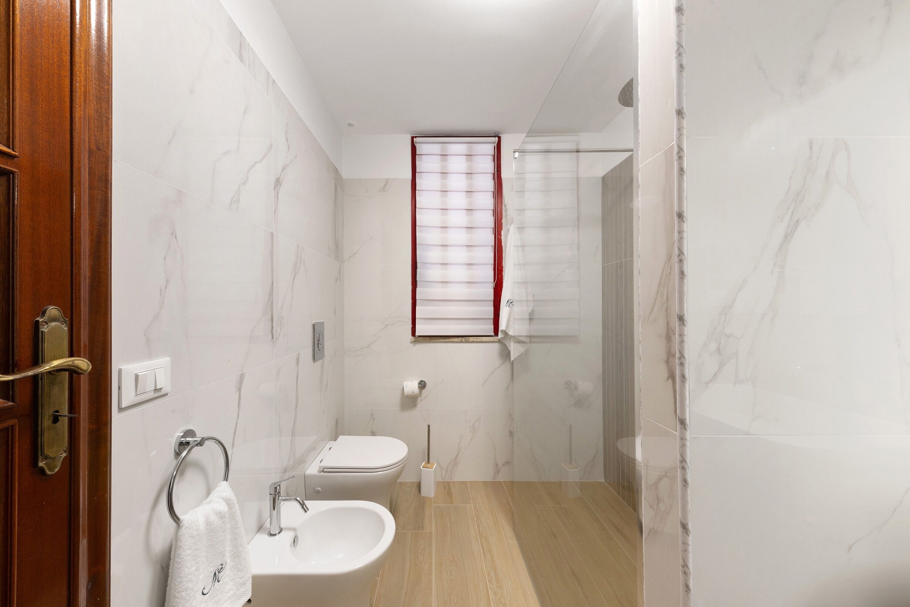 A bathroom with a toilet, sink, and shower.