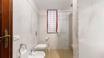 A bathroom with a toilet, sink, and shower.