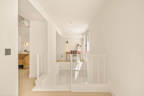 Un interno moderno con una scala, una sala da pranzo e un angolo soggiorno.