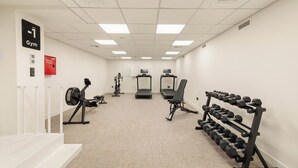 A gym with treadmills, an elliptical, and a bench press. - Grid by Zoia Living (Athens)