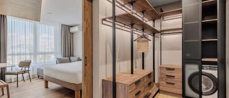 Una habitación de hotel moderna con cama, escritorio y lavandería integrada.