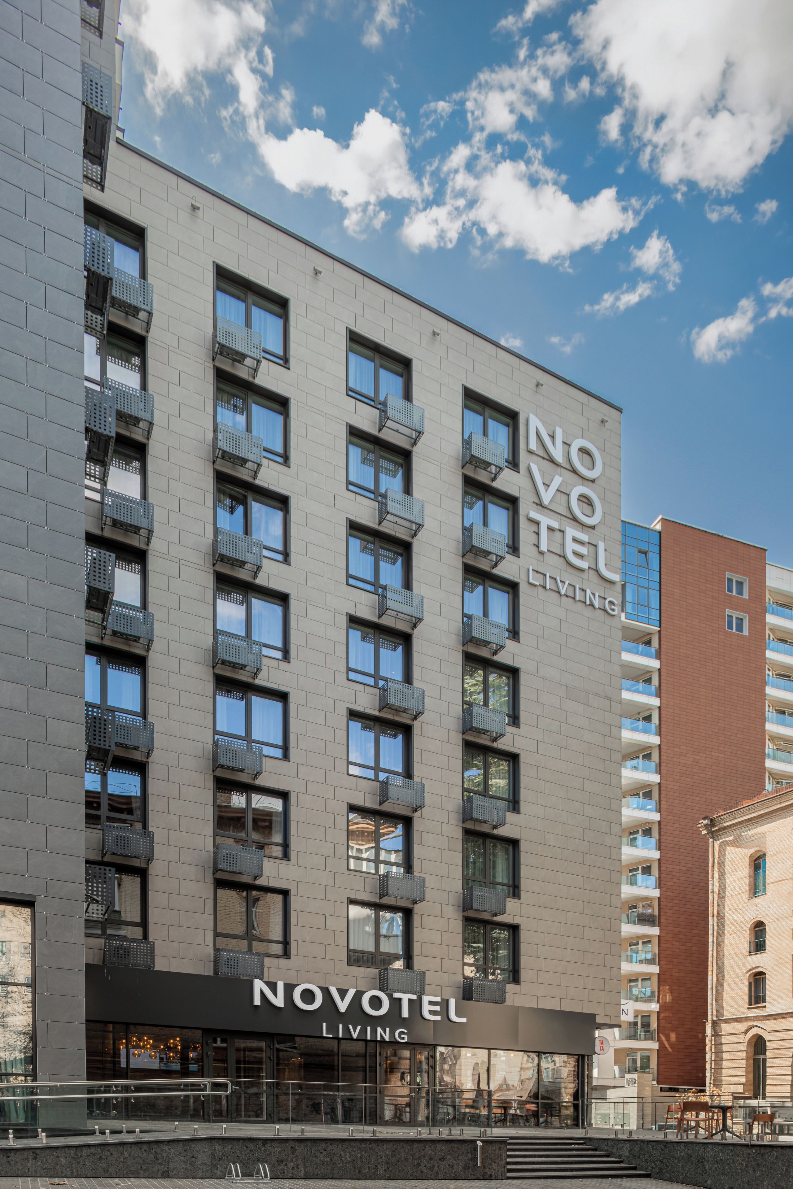 Un hôtel moderne doté de nombreux balcons et offrant une vue sur un ciel dégagé.
