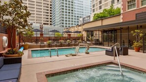 An outdoor pool area with lounge chairs, a hot tub, and a view of the cityscape. - Central Seattle Escape Near Pike Place Market & Space Needle Studio Hotel (Seattle)
