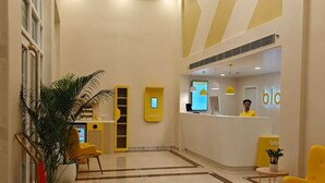 Un vestíbulo moderno con mostrador de recepción, zona de estar e iluminación decorativa.