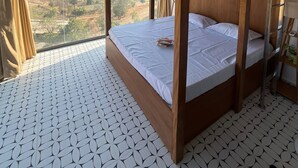 Una habitación con literas, un ventilador, una escalera y vistas al paisaje.