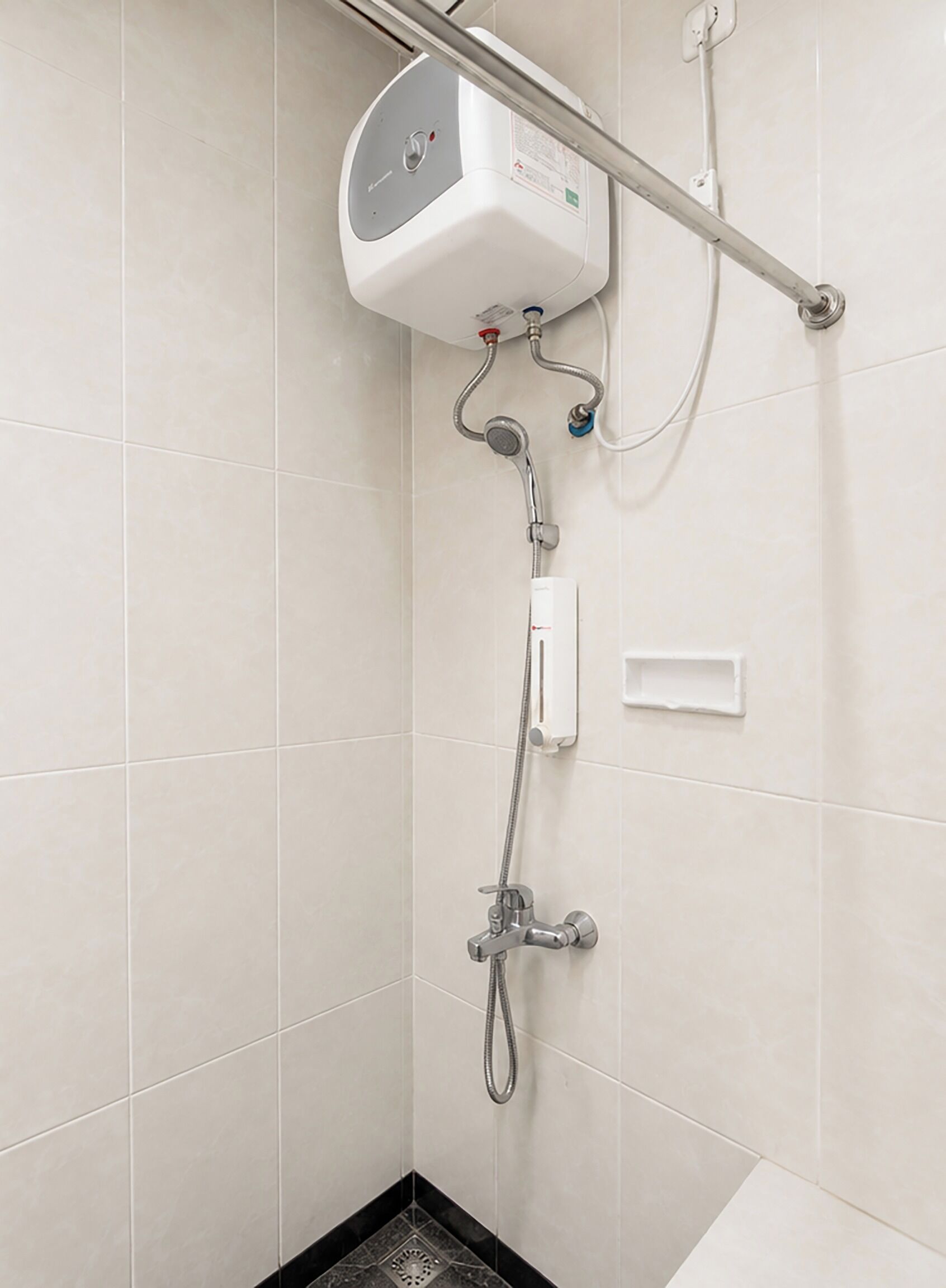 Ducha con cabezal de ducha manual, panel de control en la pared y manguera de ducha.