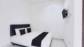 A bedroom with a bed, a wall-mounted TV, and a door.