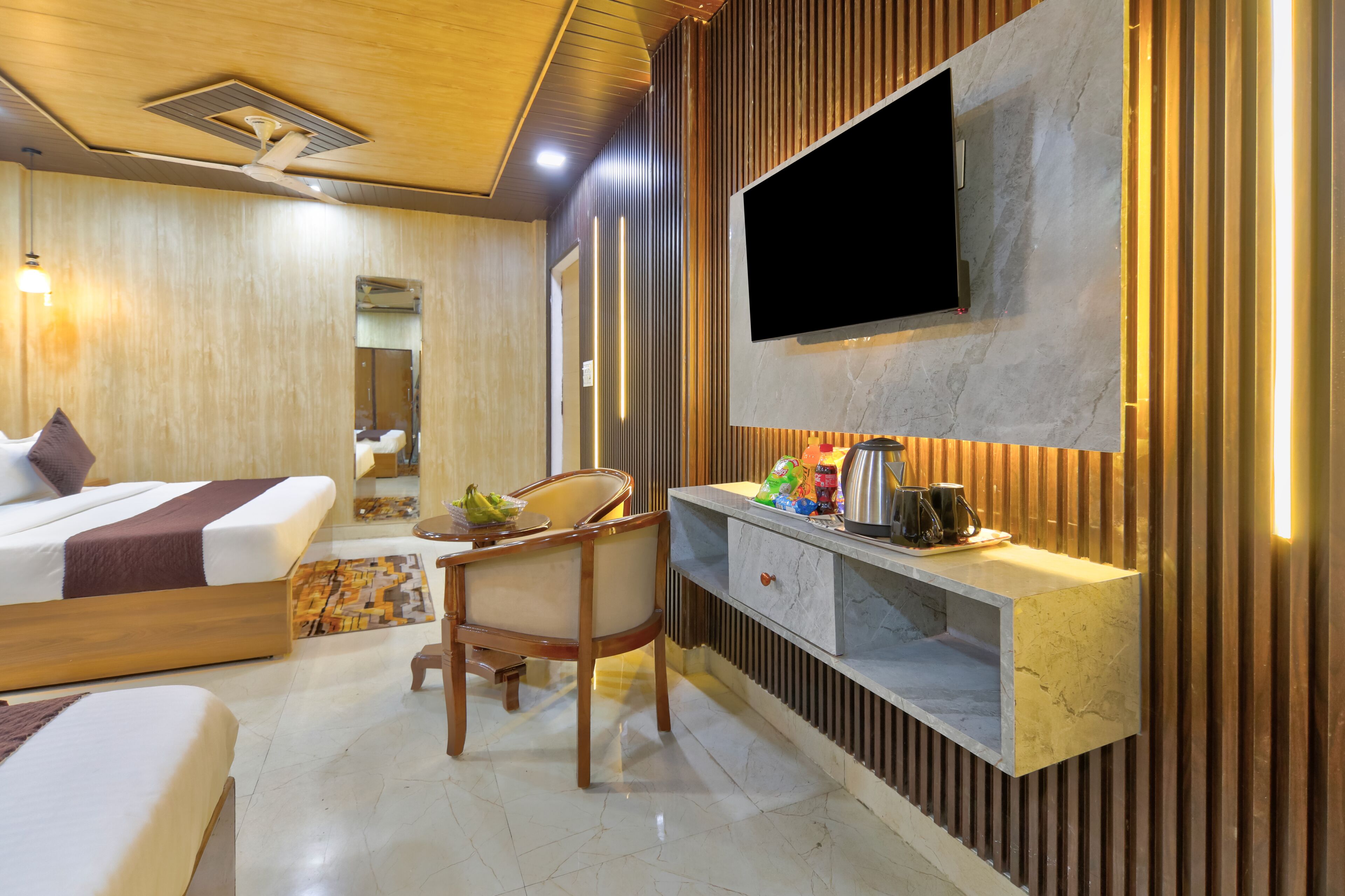 Une chambre d’hôtel comprenant un lit, un bureau, une chaise, une télévision et un miroir.