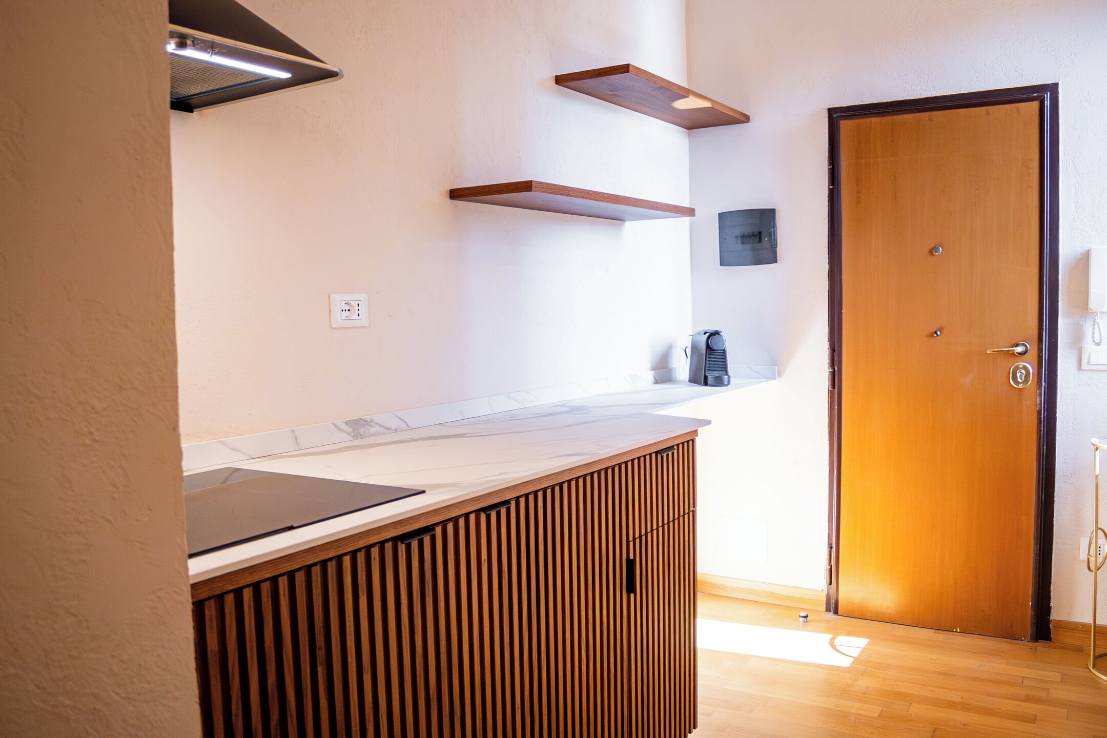 A modern kitchen with wooden cabinetry, a countertop, and a built-in stove.