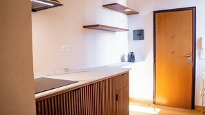 Eine moderne Küche mit Holzausstattung, einer Arbeitsplatte und einem eingebauten Herd.