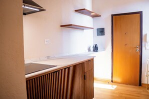 A modern kitchen with wooden cabinetry, a countertop, and a built-in stove. - In the heart of Rome, just a short walk from the Pantheon, renovated and featuring a terrace (Roma)