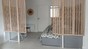 A room with a bed, a desk, a chair, and a door. - New apartment in a luxury residence on the waterfront of Lake Carcans. (Carcans)