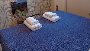 Una camera da letto con un letto, uno specchio, un termosifone e una finestra.