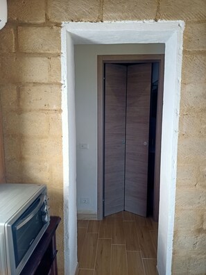 Ein Zimmer mit einer Eckwand, einer Holztür und einem eingebauten Backofen.