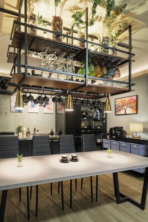 A modern kitchen with a dining area, featuring a long table, chairs, and a staircase with shelves above. - SNUGGLE2222 Odawara Nakacho / Odawara City Kanagawa (Odawara City)