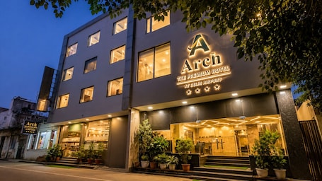 A hotel with a prominent 'Arch' sign, multiple windows, and a well-lit entrance.