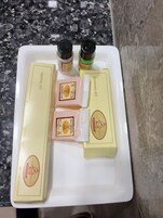 A white rectangular tray with a dental kit and shaving supplies on a granite countertop.