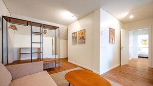 Ein modernes Interieur mit einer Couch, einem Holztisch, einer Leiter und Wandregalen.