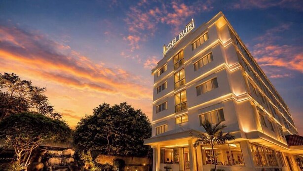 A multi-story hotel with a modern design, featuring a prominent sign at the top.