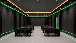 A conference room with a long table, chairs, and a dark, modern design.