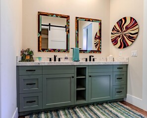A bathroom with a double sink vanity, a towel rack, a decorative mirror, and a wall-mounted round mirror. - Luxury Casita R5 - 2 Master Suites and 2.5 Bathrooms (Moab)